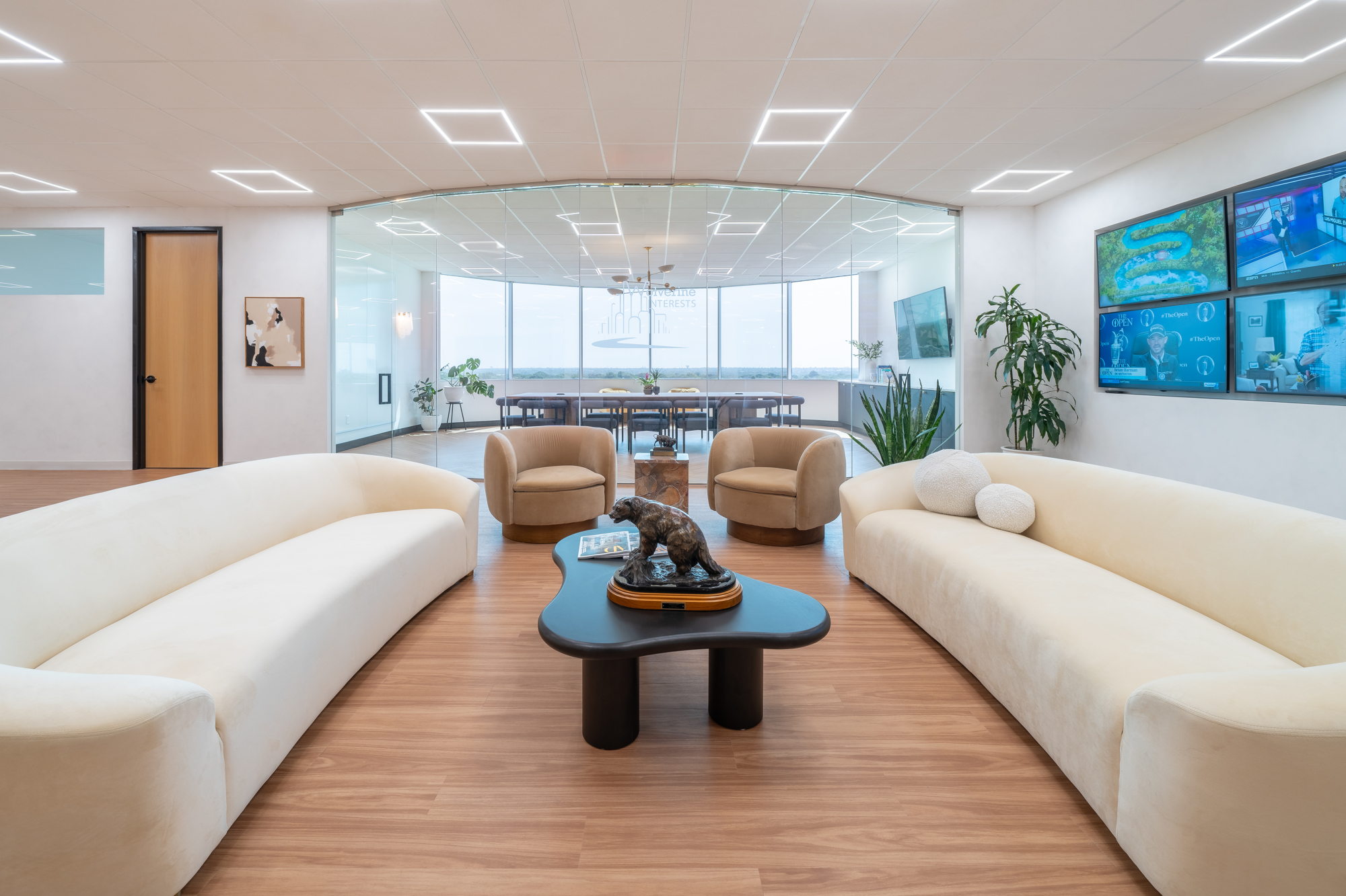 Office lounge with sculptural sofas and a glass conference room