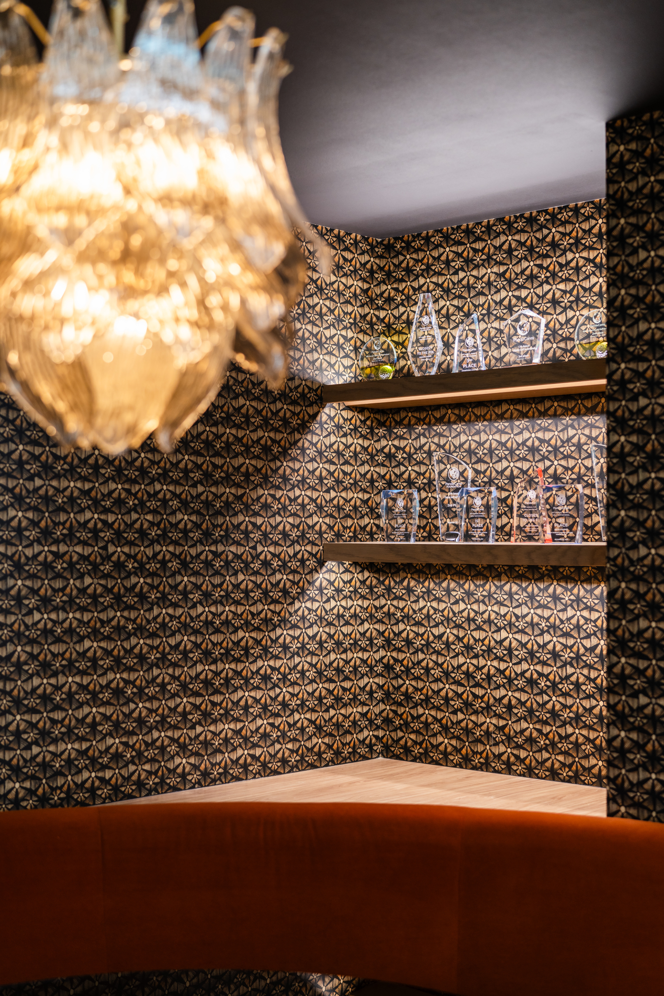 Patterned alcove with warm lighting and a rust-colored banquette